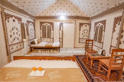 a bedroom with a bed and a table and chairs at Royal Empire Camp & Resort Jaisalmer in Sām