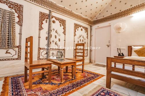 a room with a table and chairs and a bed at Royal Empire Camp & Resort Jaisalmer in Sām