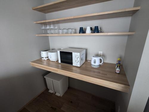 a kitchen with a counter with a microwave and appliances at Fujio Pension Madarao Apartment Hotel & Restaurant in Iiyama