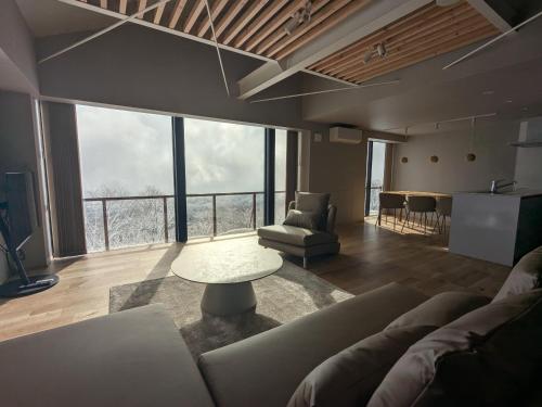 a living room with a couch and a table at Fujio Pension Madarao Apartment Hotel & Restaurant in Iiyama