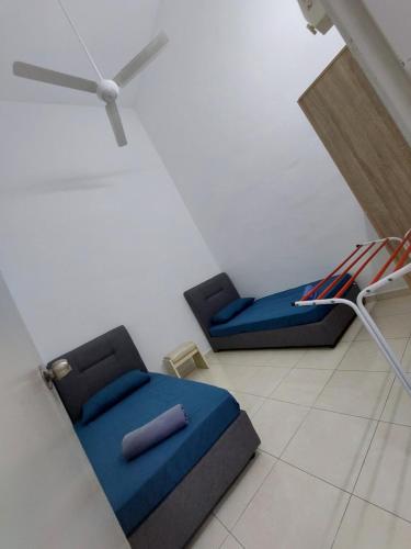 a room with two beds and a chair in it at Sun Galaxy Homestay Jasin in Bemban