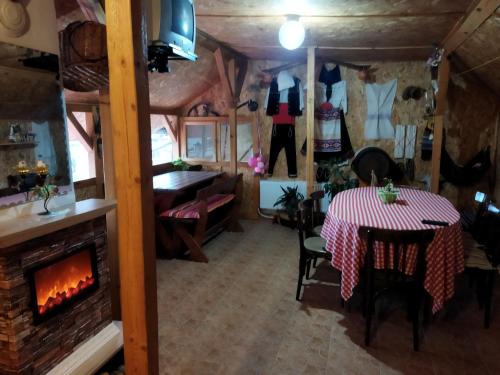 a dining room with a table and a fireplace at Къща под наем PETROVA in Cherven
