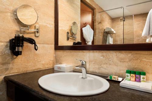 a bathroom with a sink and a mirror at Ramada Jamshedpur Bistupur in Jamshedpur