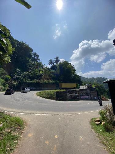 a winding road with cars parked on the side of the road at Relax mountain guest house in Badulla