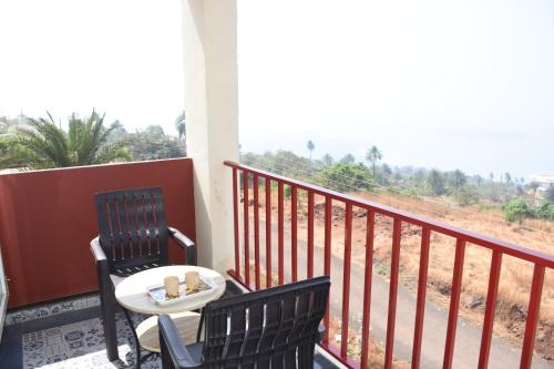 a balcony with two chairs and a table with a view at 4 Seascape in Dapoli