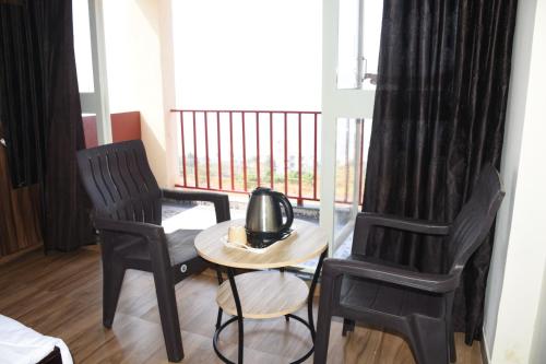 a table and two chairs in a room with a balcony at 4 Seascape in Dapoli