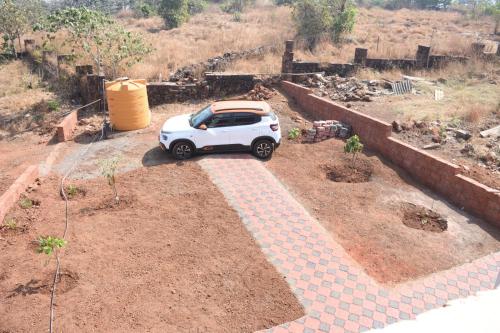 a small white car parked in a yard at 4 Seascape in Dapoli