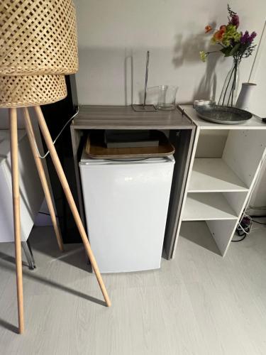 d'un bureau et d'une chaise à côté d'un petit réfrigérateur. dans l'établissement Grande Chambre Proximité Paris-Bondy 4, à Bondy