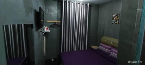 a bedroom with a purple bed and a radiator at Hotel Oasis in Batang Kali