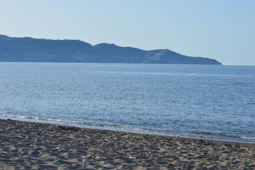 a beach with a body of water with mountains in the background at Coastal Key 6 in Gázion