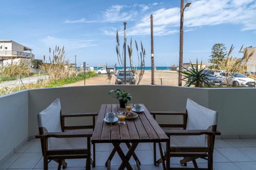 a wooden table and chairs on a balcony with a view of the beach at Coastal Key 6 in Gázion