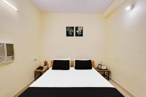 a bedroom with a large white bed with two pillows at Super Hotel O ECR Chennai Kanathur in Chennai