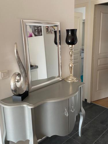 une coiffeuse en argent avec un miroir et une lampe dans l'établissement Le chantilly, à Cagnes-sur-Mer