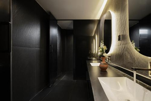 a bathroom with two sinks and a large mirror at Jinghong City Chenduo Nanshan Hotel in Xishuangbanna International Airport