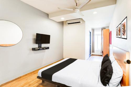 a bedroom with a bed and a flat screen tv at Super Collection O OMR Perungudi in Chennai