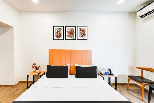 a bedroom with a large white bed and two tables at Super Collection O OMR Perungudi in Chennai