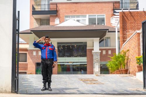 a man is standing in front of a building at Hotel Anuttara Boudha, Kathmandu in Baudhatinchule