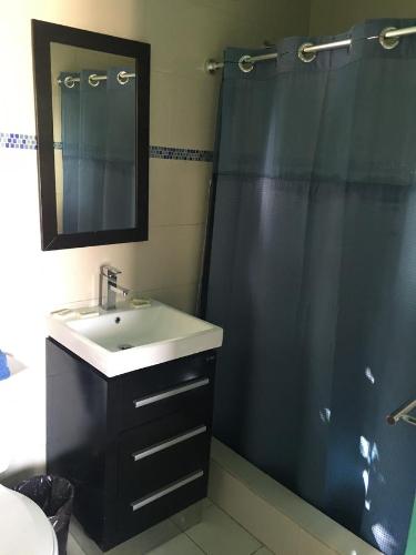 a bathroom with a sink and a shower with a mirror at Mamacitas Guest House in Culebra