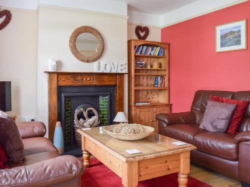a living room with two couches and a fireplace at Valentine Cottage in Keswick