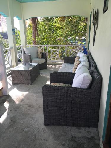 a porch with two couches and a couch and a table at Mamacitas Guest House in Culebra