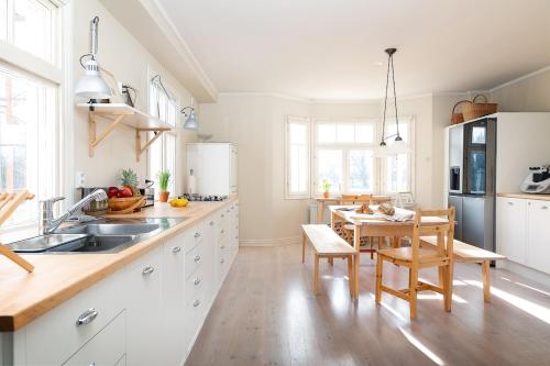 a kitchen with white cabinets and a wooden table at Stay North - Marjaniemi in Salo