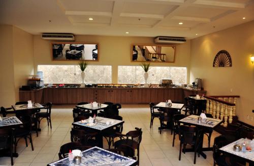 Hotel Premier في ساو لويس: غرفة طعام مع طاولات وكراسي ومطعم