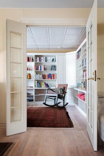 a room with a library with a chair and bookshelves at Stay North - Marjaniemi in Salo