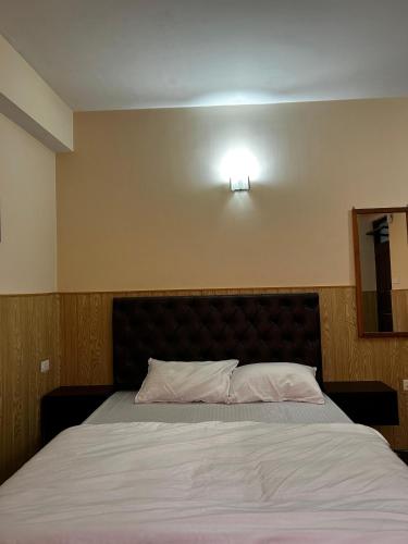 a bed in a bedroom with a light on the wall at Khangri Guest House in Gangtok