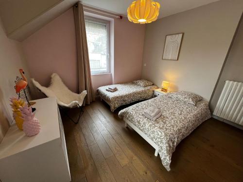 a bedroom with two beds and a window at Maison d'Alice - avec SPA in Bayeux