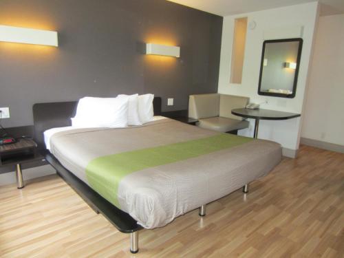 a hotel room with a large bed and a table at Studio 6-Concord, CA in Concord