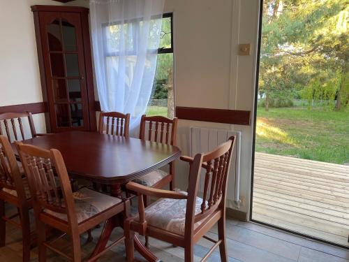 une salle à manger avec une table et des chaises et une fenêtre dans l'établissement Le Gîte des Oiseaux Un Mobil-Home au Cœur des Champs, à Bellengreville