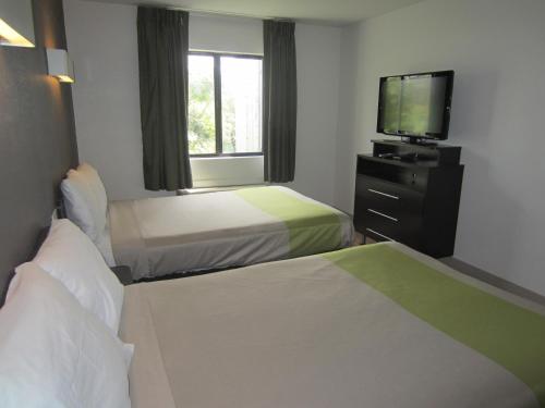 a hotel room with two beds and a flat screen tv at Studio 6-Concord, CA in Concord