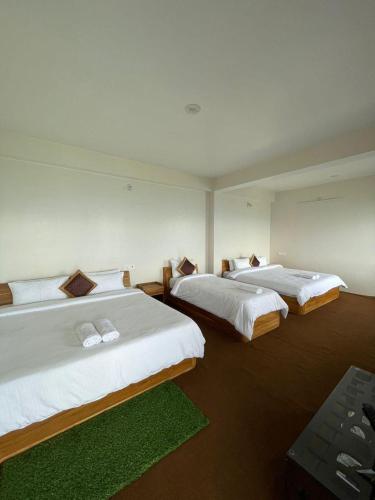 two beds in a hotel room with at Delohighs in Kalimpong