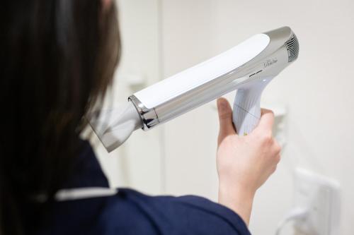 a woman holding a blow dryer in her hand at 乃宿-noyado-長崎 in Nagasaki