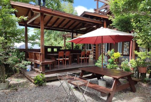 a house with a picnic table and an umbrella at Shiyai Taoyuan in Renai