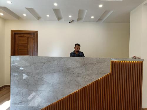 a man standing behind a counter in a room at Luxeevista - By Navodayans in Dharamshala