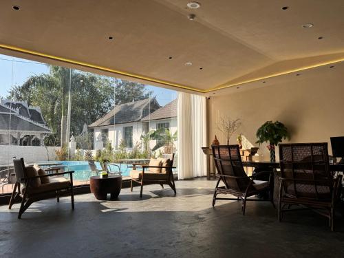 a living room with a table and chairs and a pool at Jinghong City Chenduo Nanshan Hotel in Xishuangbanna International Airport