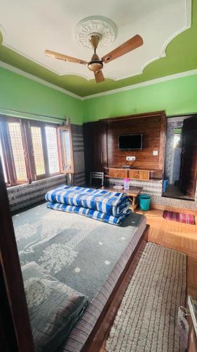a living room with a ceiling fan and a couch at Hotel Dev Bhumi in Ukhimath
