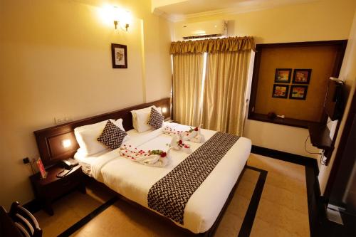 a bedroom with a bed with pillows on it at Hotel Afrad International in Kondotti
