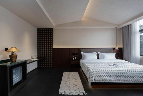 a hotel room with a bed and a television at Jinghong City Chenduo Nanshan Hotel in Xishuangbanna International Airport