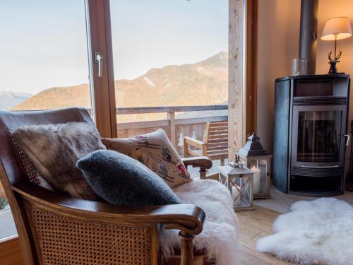 a living room with a chair and a fireplace at Chalet Petit Sapin in La Tzoumaz