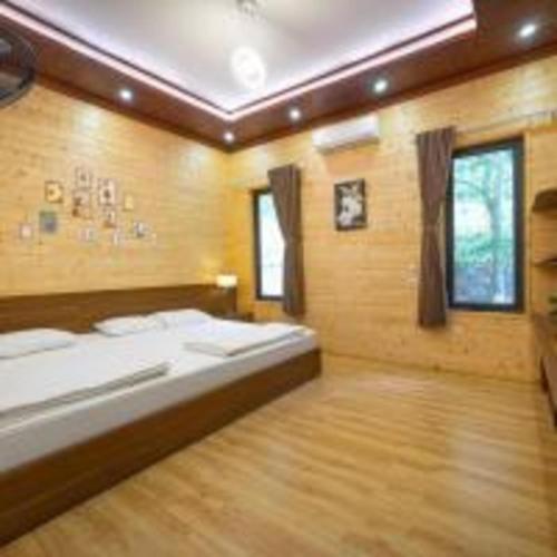 a bedroom with a bed and a wooden floor at SH Homestay - Venuestay in Sóc Sơn