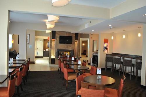a restaurant with tables and chairs and a fireplace at Holiday Inn Express Pittsburgh - Munhall by IHG in Munhall