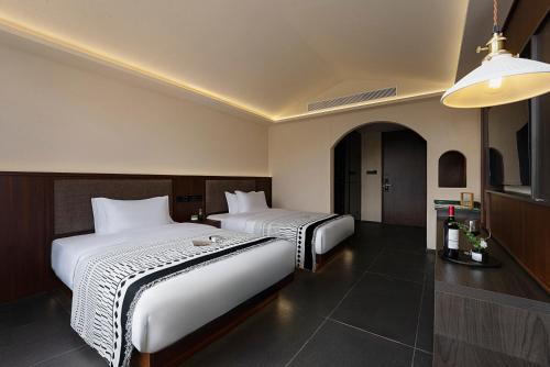 a hotel room with two beds in a room at Jinghong City Chenduo Nanshan Hotel in Xishuangbanna International Airport