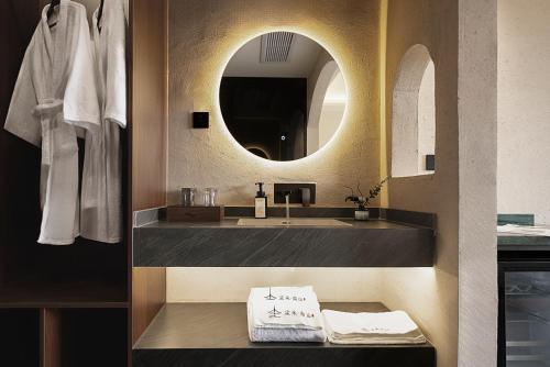 a bathroom with a sink and a mirror at Jinghong City Chenduo Nanshan Hotel in Xishuangbanna International Airport
