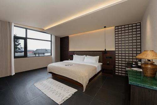 a hotel room with a bed and a large window at Jinghong City Chenduo Nanshan Hotel in Xishuangbanna International Airport
