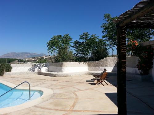 a patio with a chair and a swimming pool at Al Jatib in Baza
