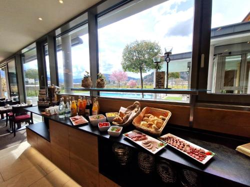 a buffet in a restaurant with food on a counter at Mosers Blume Relax & Genuss Hotel in Haslach im Kinzigtal