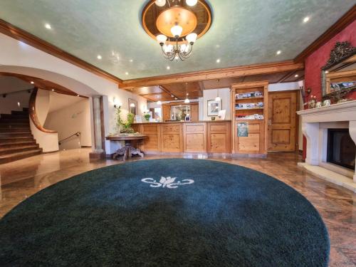 a large living room with a blue carpet and a fireplace at Mosers Blume Relax & Genuss Hotel in Haslach im Kinzigtal