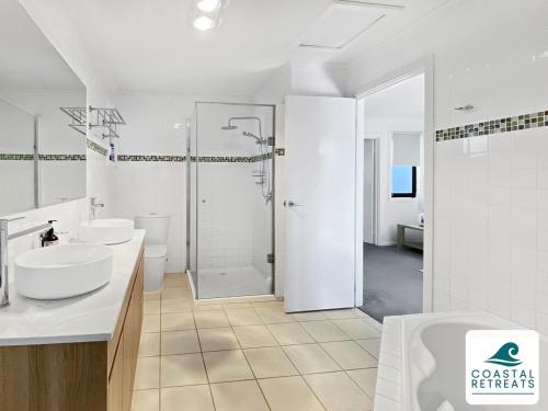 a white bathroom with two sinks and a shower at Town & Tide, Cowes Central in Cowes